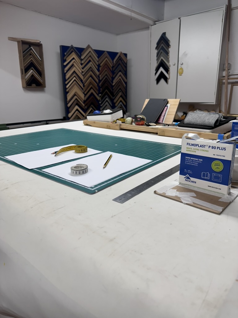 Conservation framing detail — moulding samples and acid-free tape at the Glasgow studio