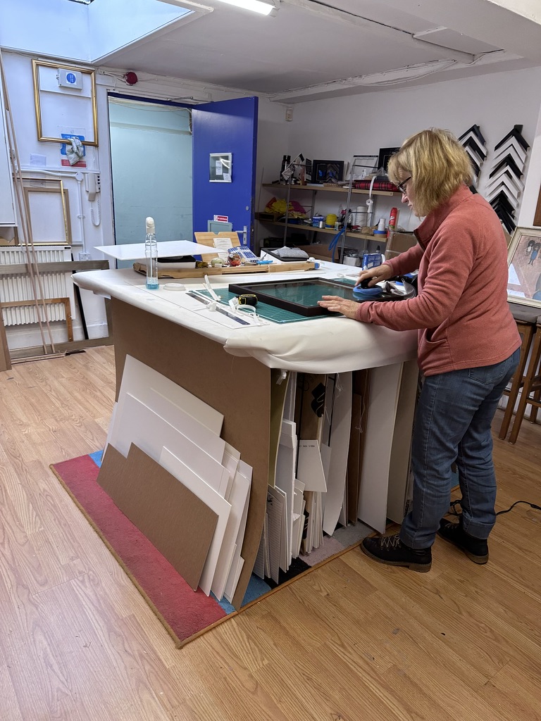 A course guest gluing and assembling her frame at Frank Marker Framers, Govan